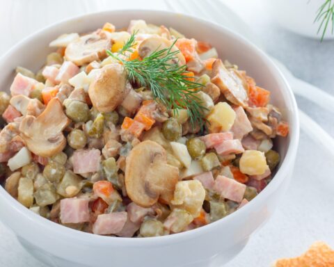 Оливье с колбасой и маринованными шампиньонами в новогоднем меню