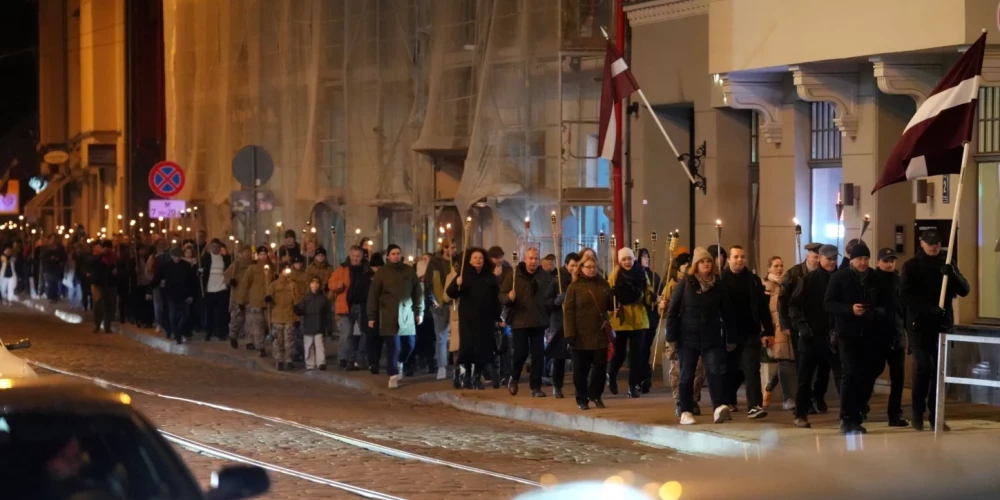 Сотни людей участвуют в факельном шествии по всей Латвии