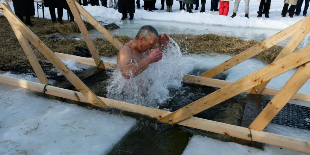 Верующие в Даугавпилсе окунаются в ледяную воду на праздник Крещения Господня