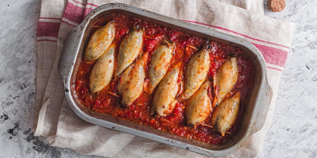 Фаршированные кальмары с рисом, колбасой и помидорами в духовке