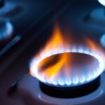 Горящая газовая конфорка на плите крупным планом.