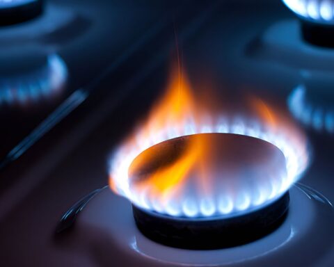 Горящая газовая конфорка на плите крупным планом.