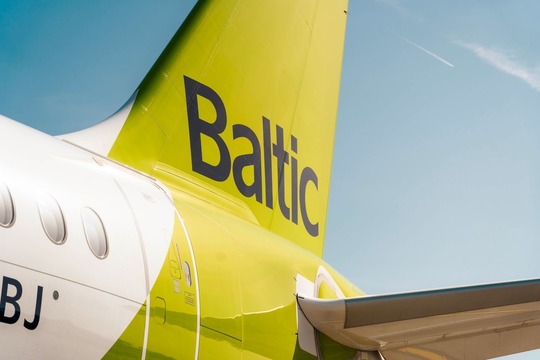 Хвостовая часть самолета airBaltic с фирменной зеленой окраской и логотипом Baltic.