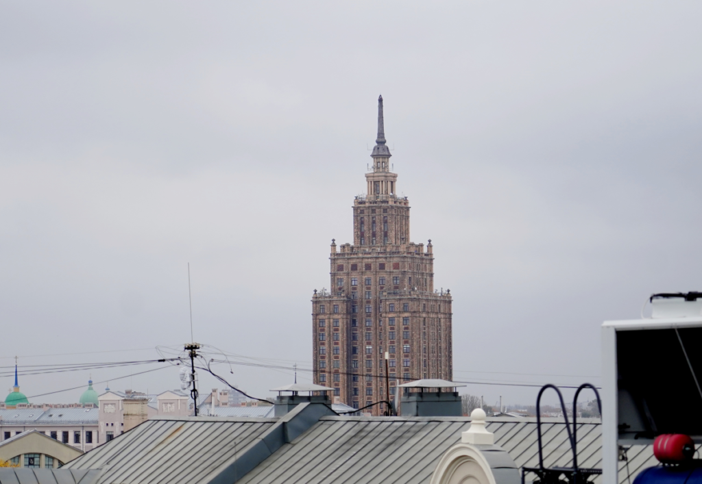 Высотное здание в городском пейзаже под пасмурным небом.