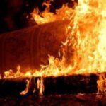 Горящий объект в темноте, вокруг пламя и густой огонь.