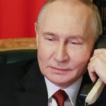 Владимир Путин разговаривает по телефону в кабинете.