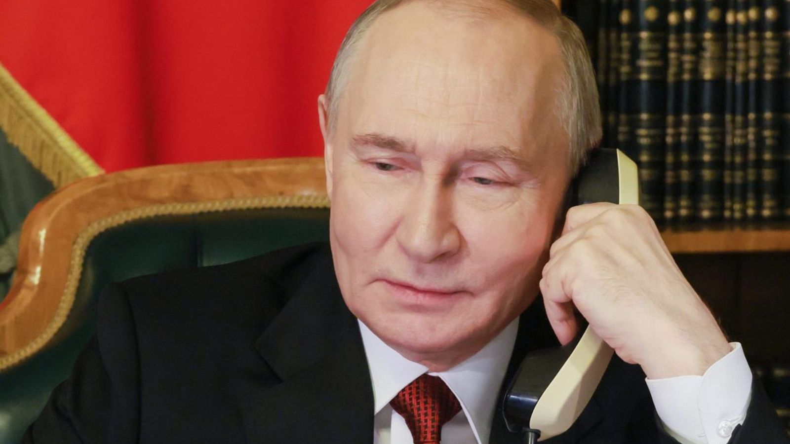 Владимир Путин разговаривает по телефону в кабинете.