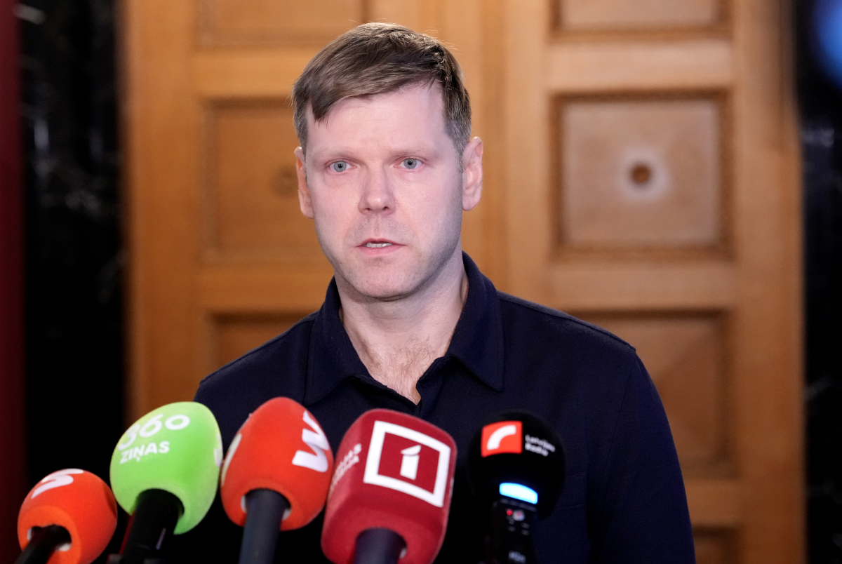 Мужчина выступает перед прессой у микрофонов во время заявления.