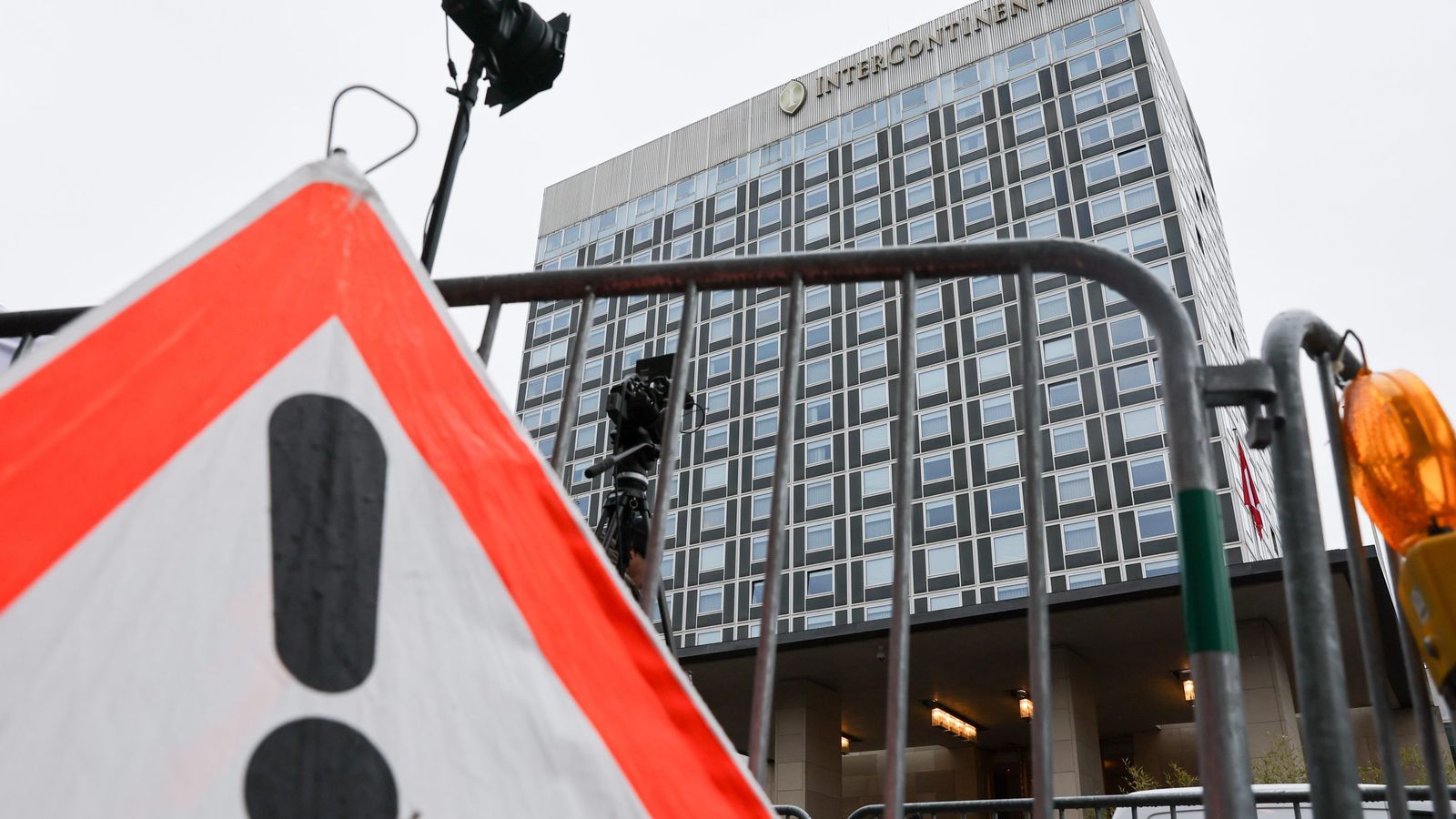 Фасад отеля InterContinental, снятый снизу за металлическими ограждениями и дорожным знаком.
