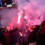 Депутаты в зале парламента держат зажжённый файер, помещение заполнено дымом.