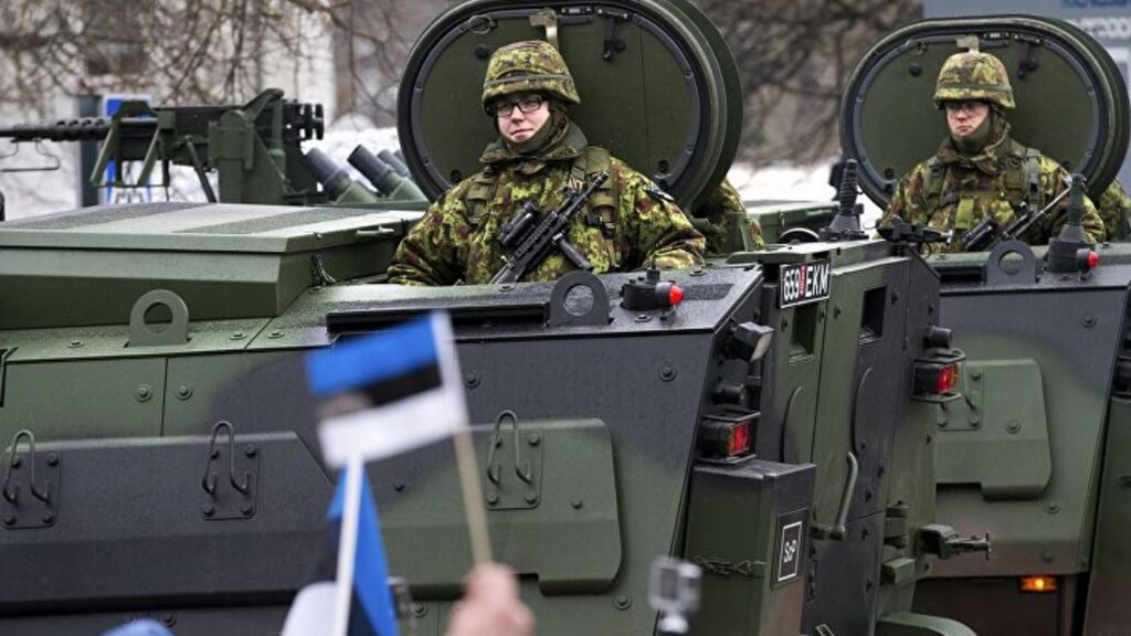 Эстонские военные сидят в бронетехнике во время движения колонны.