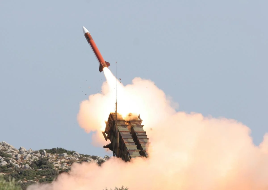 Ракета Patriot стартует из зенитной установки на фоне облака дыма.