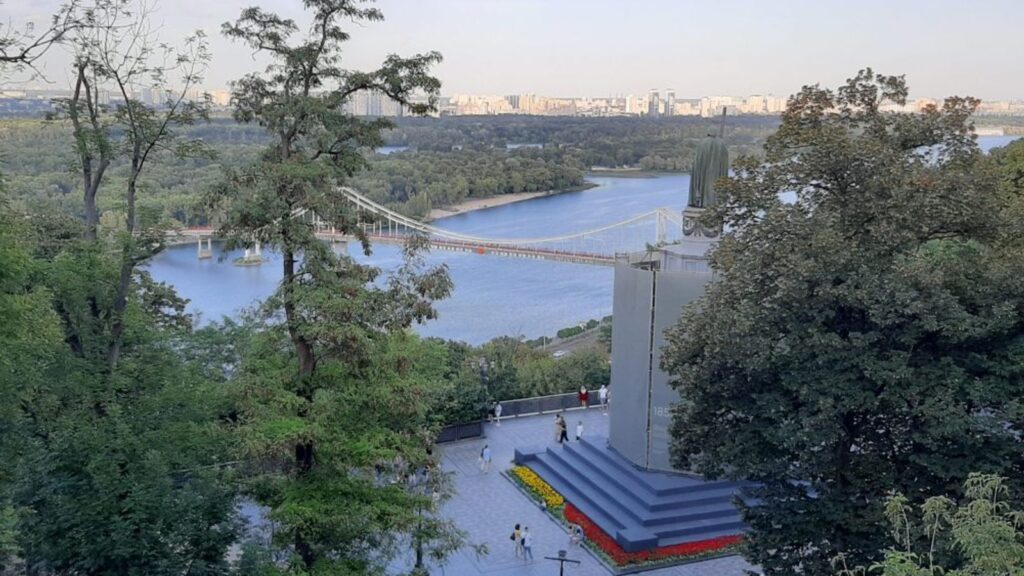 Вид на реку Днепр, пешеходный мост и городской пейзаж Киева с холма