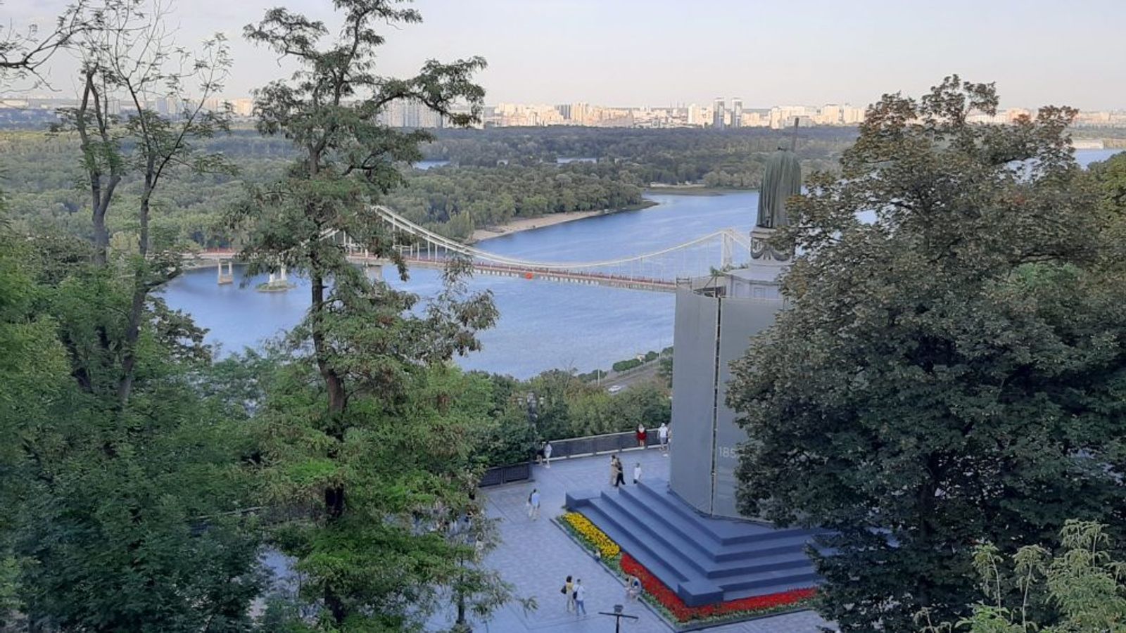 Вид на реку Днепр, пешеходный мост и городской пейзаж Киева с холма