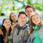 Группа подростков делает селфи на улице в солнечный день.