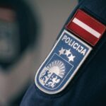 Крупный план нашивки латвийской полиции на форме сотрудника.