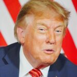 Дональд Трамп крупным планом на фоне красно-белых полос.