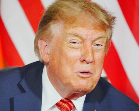 Дональд Трамп крупным планом на фоне красно-белых полос.