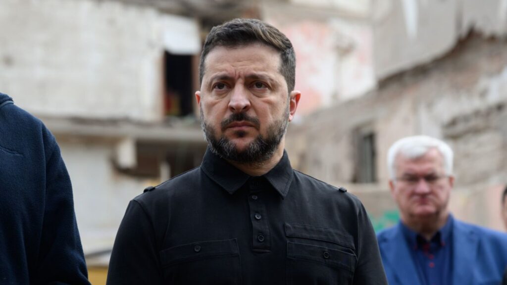 Володимир Зеленський на фоне разрушенного здания во время визита.