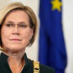 Портрет Юлле Мадизе на фоне флагов Эстонии и ЕС.
