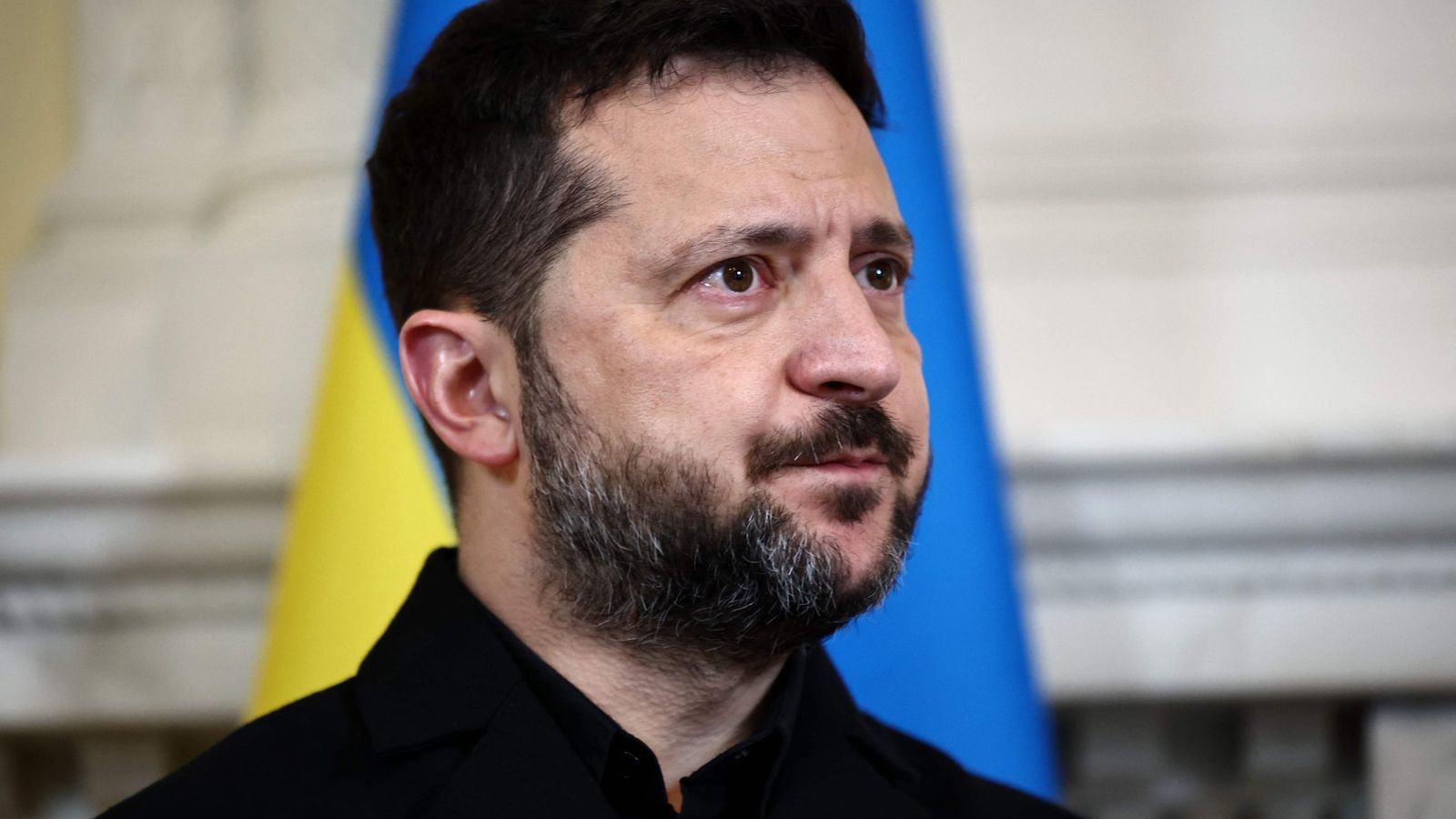 Владимир Зеленский на фоне украинского флага.