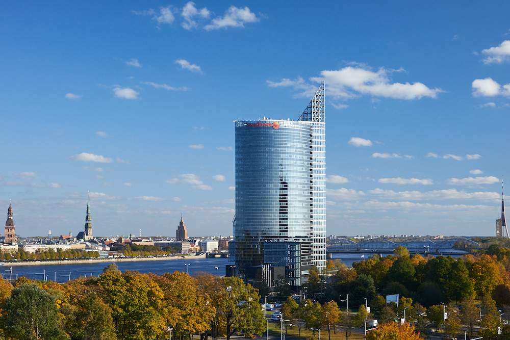 Skyscraper Swedbank в городском пейзаже на фоне реки и неба.