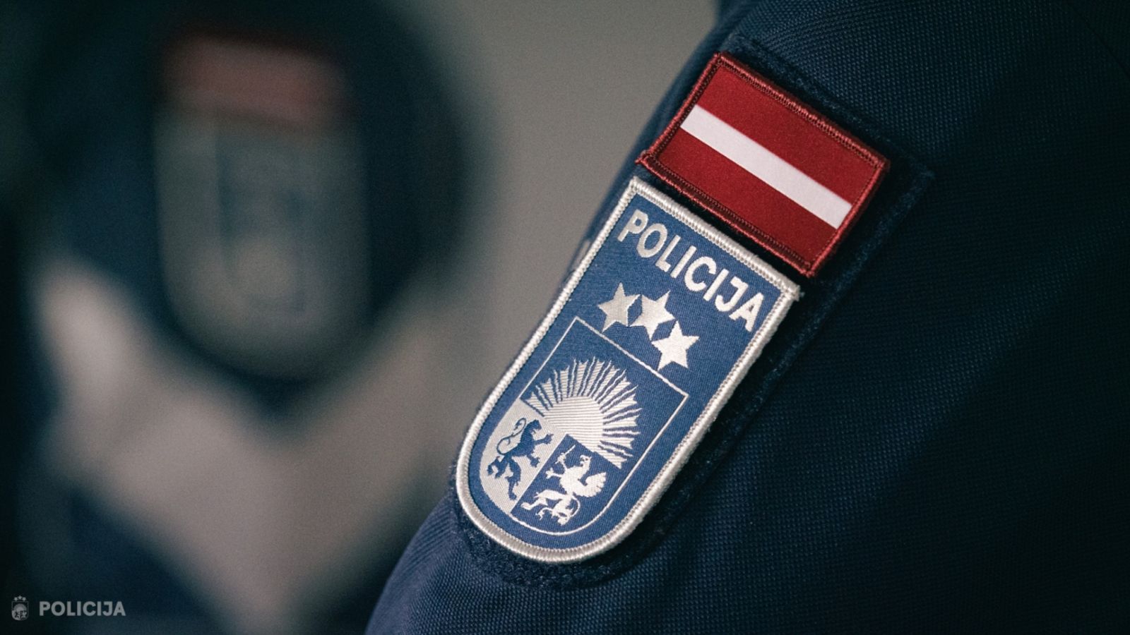 Крупный план нашивки латвийской полиции на форме сотрудника.