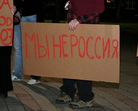 Участники протеста держат картонные плакаты с надписью «Мы не Россия».