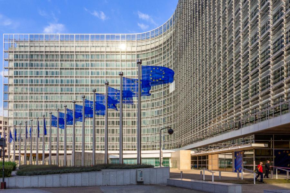 Фасад здания Еврокомиссии с рядом флагов Европейского союза.
