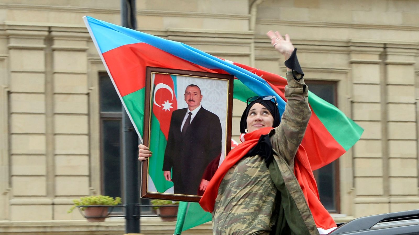 Женщина с флагом Азербайджана и портретом Ильхама Алиева на акции.